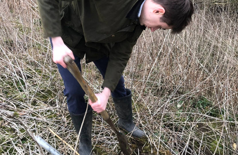 Aubrey planting a tree in Chipping